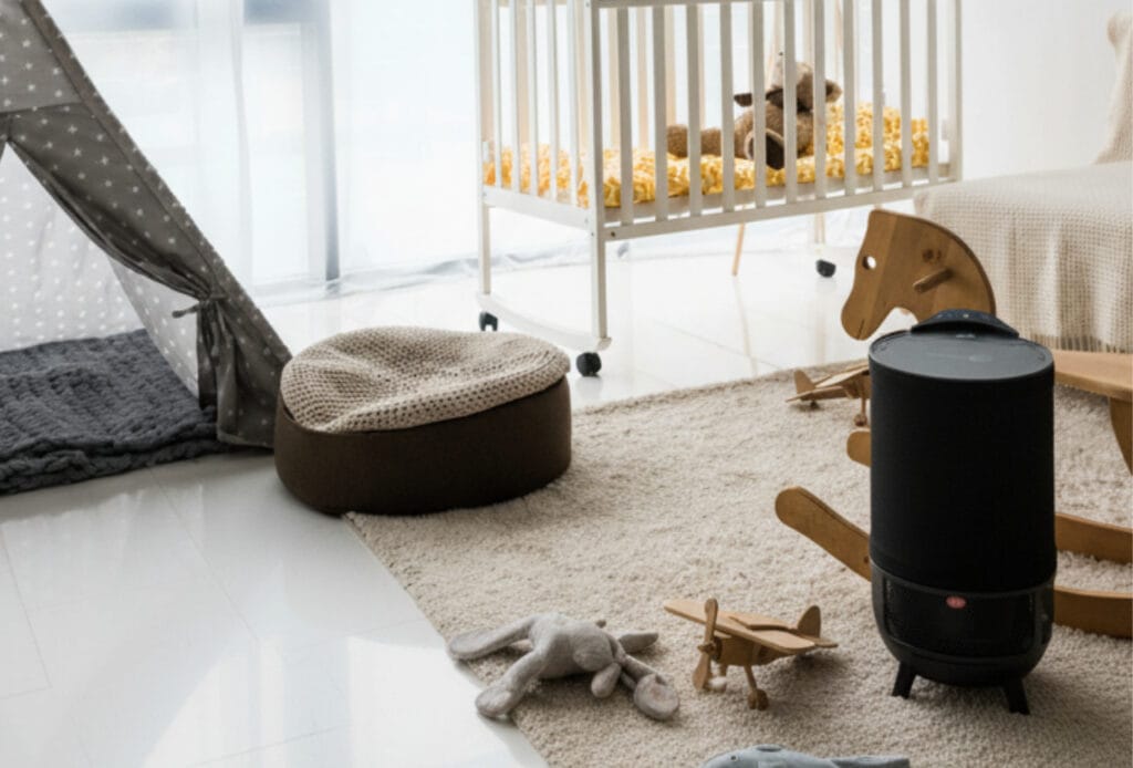 Aeroguard 360 PRO & Premium A cosy nursery with a cot, rocking horse, soft toys, a grey tent, and an air purifier by Lux Aeroguard 360 PRO & Premium on a beige rug. Sunlight streams in through the window, creating a warm and inviting atmosphere.