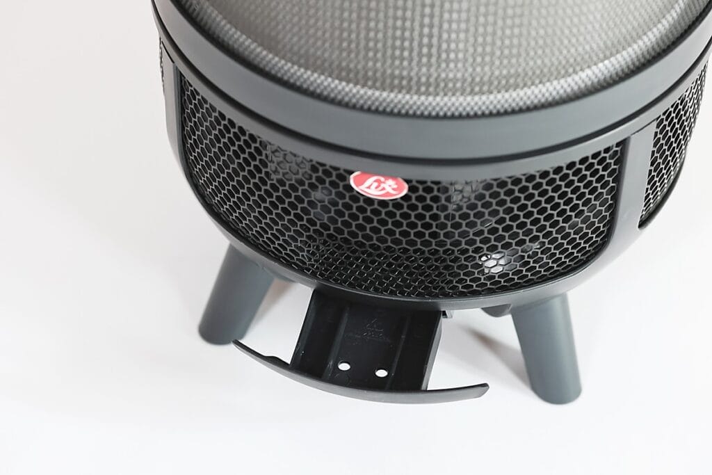 Aeroguard 360 PRO & Premium Close-up of a black, round metal fire pit on three legs, featuring a mesh screen and a small pull-out ash tray at the bottom. The fire pit sits on a white surface—modern in style like the Aeroguard 360 PRO & Premium air purifier by Lux.