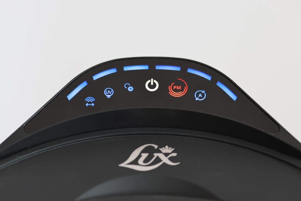 Aeroguard 360 PRO & Premium Close-up of a control panel with blue-lit icons and a red PM indicator, including power, UV, and Wi-Fi symbols, on a device labelled “Lux”.